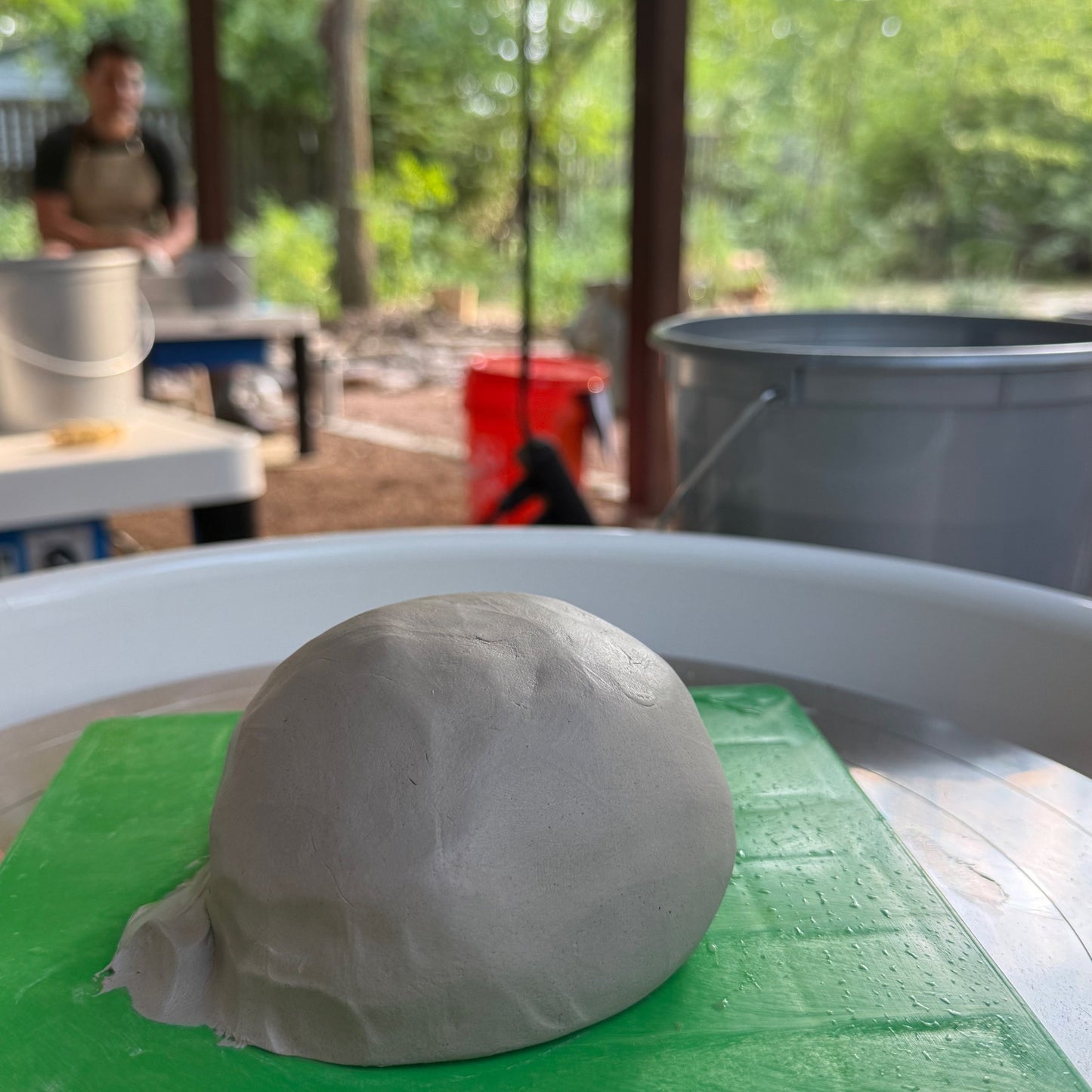 Piece of clay prior to being spun on a wheel in the middle of a ceramics class in an outdoor setting located in Austin TX
